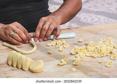 Local woman preparing in the street of Bari old town orecchiette or orecchietta, made with durum wheat and water, handmade pasta typical of Puglia or Apulia, a region of Southern Italy, close up