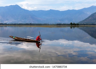 a local woman in red dress boating in dal lake, jammu and kashmir, india