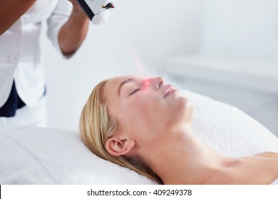 Localized cryotherapy session to the face of young caucasian woman. Ice cold nitrogen vapors applied to the facial skin, this eliminates inflammation, flush out dirt and toxins from the skin.