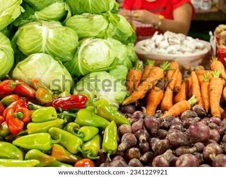 Locally produced Filipino veg.Cabbage,lettuce,green and red peppers,carrots,garlic,ginger,red and white onions,carefully arranged and stacked, and for sale at a local covered market.