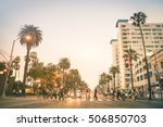 Locals and tourists walking on zebra crossing on Ocean Ave in Santa Monica after sunset - Crowded streets of Los Angeles and California state - Warm desat twilight color tones with blurred people