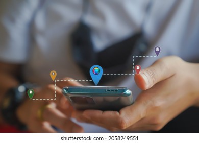 Location Search App Concept. Man Use Mobile Phone Searching Locations Gas Station, Restaurant, Hotel, Bank And Earth Icon Raise Up From Screen Display