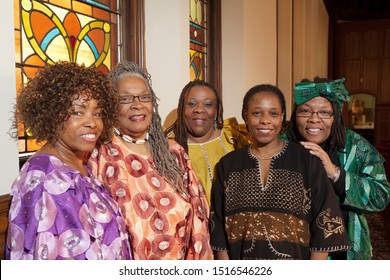 Location shot of colorfully dressed older African women dressed in colorful outfits in a church. 