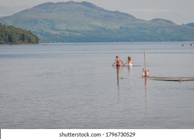 Loch Lomond, Scotland, United Kingdom. August 11 2020. A Couple Go For A Swim In The Loch Lomond Lake In The Lowlands Area Of Scotland.