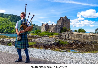 Lochash,  Scotland -  June 20, 2012: Highlands, A Bagpipe Player And The Eilean Conan Castle In Background.