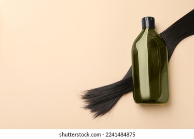 Lock of hair and shampoo bottle on beige background, flat lay. Space for text - Shutterstock ID 2241484875