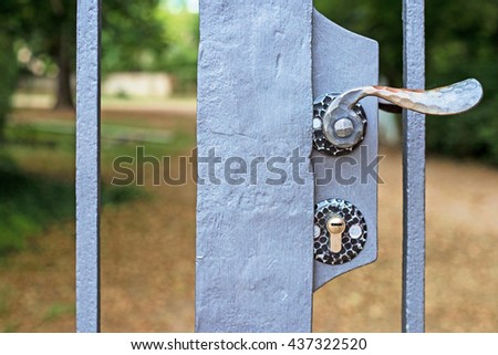 Lock and metal door handle in closed Park gates. Closed door. Metal garden gates shut. Outdoor locked gate