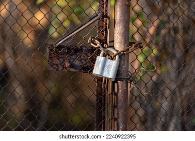 lock on an old rusty mesh gate, chain link fence