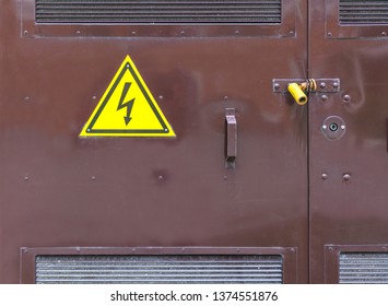 Locked steel door of a transformer substation with a high voltage sign. - Shutterstock ID 1374551876