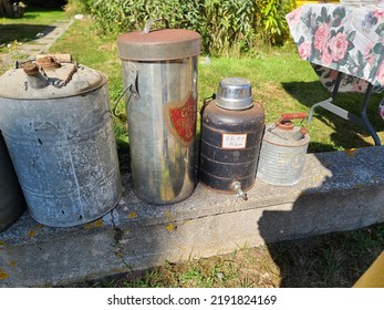 Lockeport, NS, CAN, August 13, 2022 - Old Gas Cans For Sale That Are Setup Along A Cement Wall.