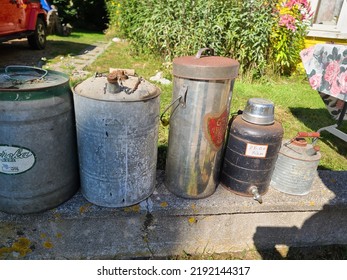 Lockeport, NS, CAN, August 13, 2022 - Old Gas Cans For Sale That Are Setup Along A Cement Wall.