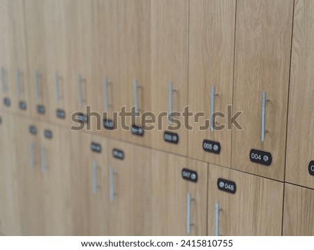 Locker room in the gym, wooden drawers for clothes. Changing room closeup. Lockers in gymnasium. Wooden texture. Secure place to leave the things. Selective focus. Interior of a locker room. 