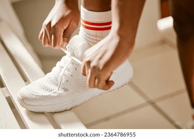 Locker room, sports and person tie shoes for training, exercise and workout for practice or match. Fitness, gym and closeup of athlete tying laces for performance, wellness and ready for competition - Powered by Shutterstock