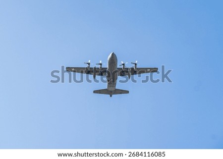 Lockheed C-130 Hercules soaring high in clear blue skies during a training mission over a coastal area