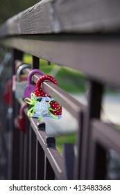  Locks on railing of bridge, which hang brides and grooms.Focus on red lock with decor.
