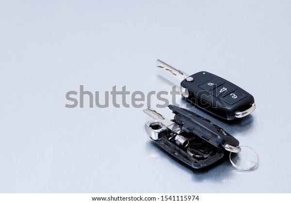 Locksmith broken or\
damaged car key fob and new remote vehicle key on aluminium\
background. Repair of broken or damaged remote key fob of any\
vehicle car service.-\
Image
