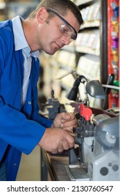 A Locksmith Duplicating A Key