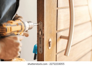 Locksmith hands, maintenance and handyman with drill, home renovation and fixing, change door locks and power tool. Construction, building industry and trade with manual labour, vocation and employee