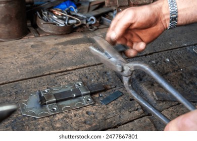 Locksmith in his workshop makes duplicate of a key.