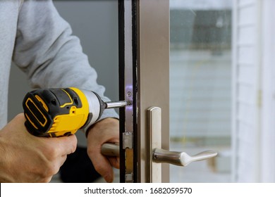 Locksmith In Installing New House Door Lock Hand Holds The Screwdriver