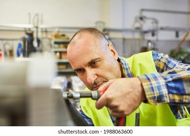 Locksmith Or Metal Worker Works With Screw Clamp On A Workbench In The Workshop