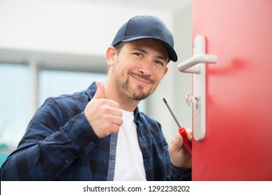 locksmith with screwdriver holding thumbs up