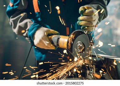 Locksmith in special clothes and goggles works in production. Metal processing with angle grinder. Sparks in metalworking - Powered by Shutterstock