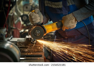 Locksmith in special clothes and goggles works in production. Metal processing with angle grinder. Sparks in metalworking - Powered by Shutterstock