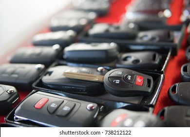 Locksmith stand with variety of car and van keys remote on red background