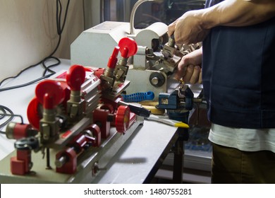 Locksmith in workshop makes new key. Professional making key in locksmith.