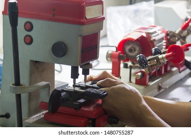 Locksmith in workshop makes new key. Professional making key in locksmith.