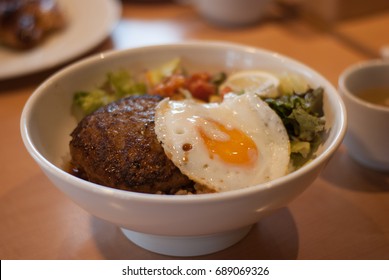 Loco moco is a meal in the contemporary cuisine of Hawaii. There are many variations, but the traditional loco moco consists of white rice, topped with a hamburger patty, a fried egg, and brown gravy.