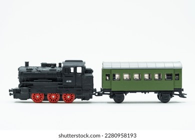 Locomotive and green wagon of toy train on a white background