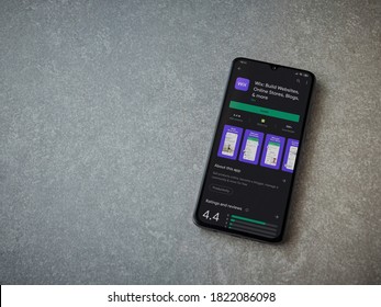 Lod, Israel - July 8, 2020: Wix app play store page on the display of a black mobile smartphone on ceramic stone background. Top view flat lay with copy space.