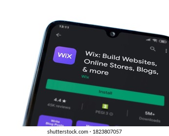 Lod, Israel - July 8, 2020: Wix app play store page on the display of a black mobile smartphone isolated on white background. Top view flat lay with copy space.