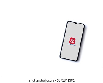 Lod, Israel - July 8, 2020: Super Pharm app launch screen with logo on the display of a black mobile smartphone isolated on white background. Top view flat lay with copy space.