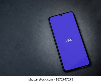 Lod, Israel - July 8, 2020: Wix app launch screen with logo on the display of a black mobile smartphone on dark marble stone background. Top view flat lay with copy space.