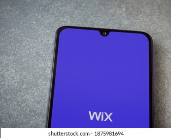 Lod, Israel - July 8, 2020: Wix app launch screen with logo on the display of a black mobile smartphone on ceramic stone background. Top view flat lay with copy space.