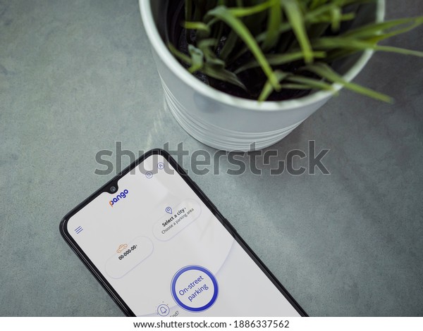 Lod, Israel - July 8, 2020: Modern minimalist\
office workspace with black mobile smartphone with Pango app launch\
screen with logo on marble background. Top view flat lay with copy\
space.