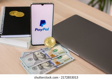 Lodz, Poland - June 21, 2022: Paypal Application On Smartphone Near Dollar Bills And Crypto Currency And Laptop