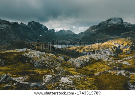 Lofoten Islands Norway. Mountain autumn landscape. Hike to Mount Munken, alpine lake against a stormy sky