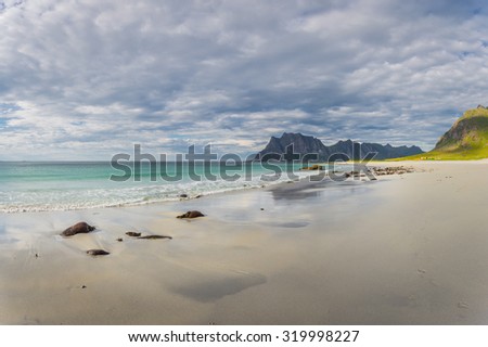 Lofoten, Norway. Uttakleiv beach during a wonderful, cloudy afternoon, with rocks and sand on the foreground.