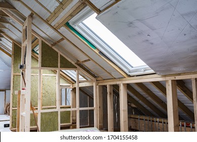 Loft conversion, unfinished project, silver insulation, roof windows, wood structure of the walls, selective focus