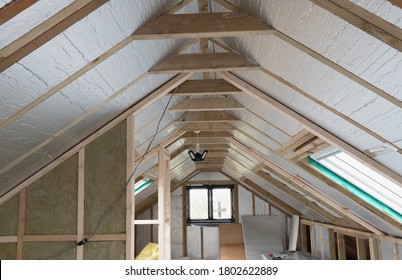 Loft conversion, unfinished project, silver insulation, roof windows, wood structure of the walls, selective focus - Shutterstock ID 1802622889