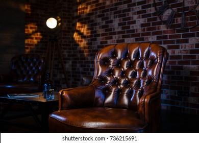Loft interior mock up grey block wall with leather chair and vintage light source lamp