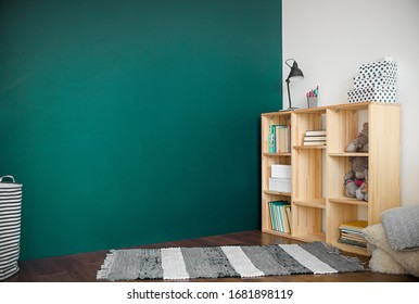 Loft Interior With A Woden Bookcase With Book And Rug On Wood Floor And Green Wall