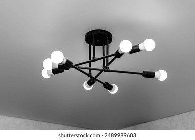 loft minimalism style black chandelier with white LED lamps on a white matte stretch ceiling