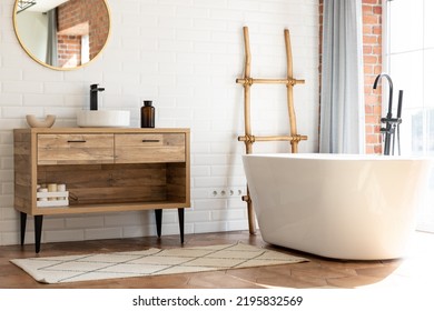 Loft modern style bathroom. Free standing bath and black faucet for water and white separate high sink on wooden pedestal. - Powered by Shutterstock