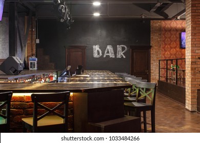 Loft Style Bar Interior With Wooden Countertop, Bar Chairs, Bricks Wall