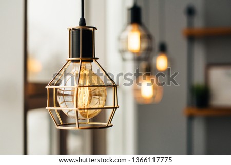 Loft style light bulbs glowing near window. Warm light. Coffee shop interior.